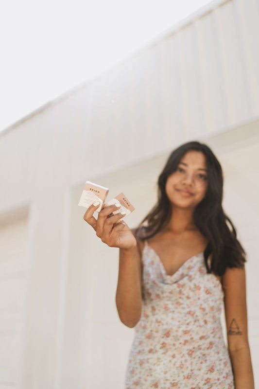 A woman holding two shampoo bars in her hand 